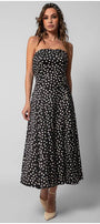 Model wearing a black elegant midi dress black and ivory polka dot strapless satin midi dress with a fitted bodice and flowing skirt