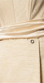 Fabric close-up of Melisa beige dress showing ribbed texture, smooth waist sash, and Luna accent.