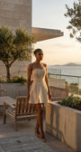 Melisa beige strapless mini corset dress styled on a coastal terrace at golden hour.