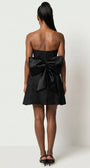 Back view of Melisa black mini dress with oversized removable bow, center zipper, and flared skirt.