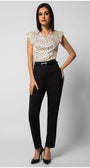 Woman wearing sleeveless satin polka dot elegant blouse with decorative buttons paired with tailored black pants and heels