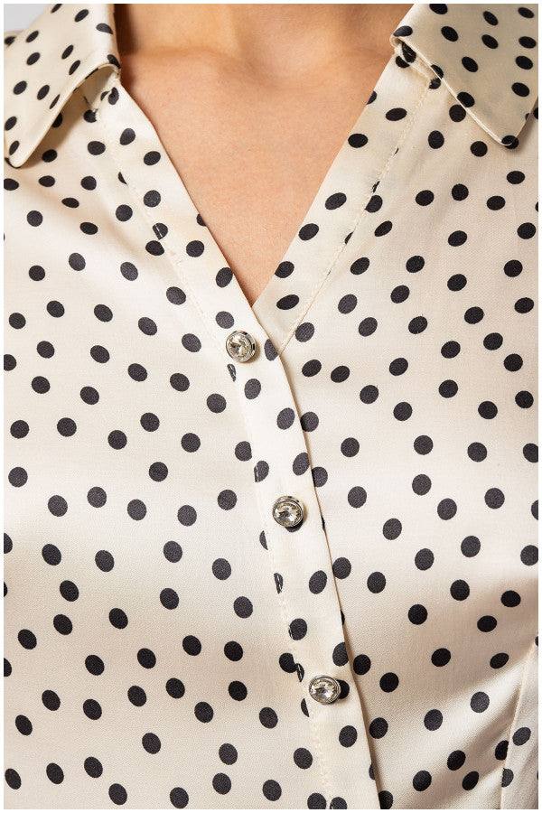 Close-up of Talia satin elegant blouse with black polka dots and decorative diagonal buttons on ivory fabric