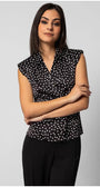 Woman wearing a sleeveless black satin elegant blouse with white polka dots and decorative diagonal buttons, styled professionally.