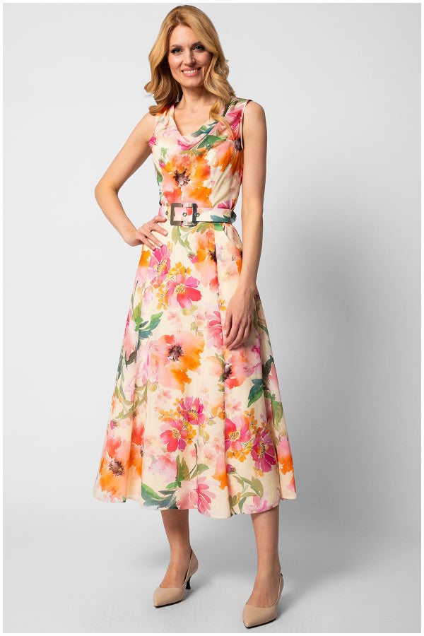 Woman wearing sleeveless colorful floral elegant midi dress with belted waist and flowing silhouette standing against white background