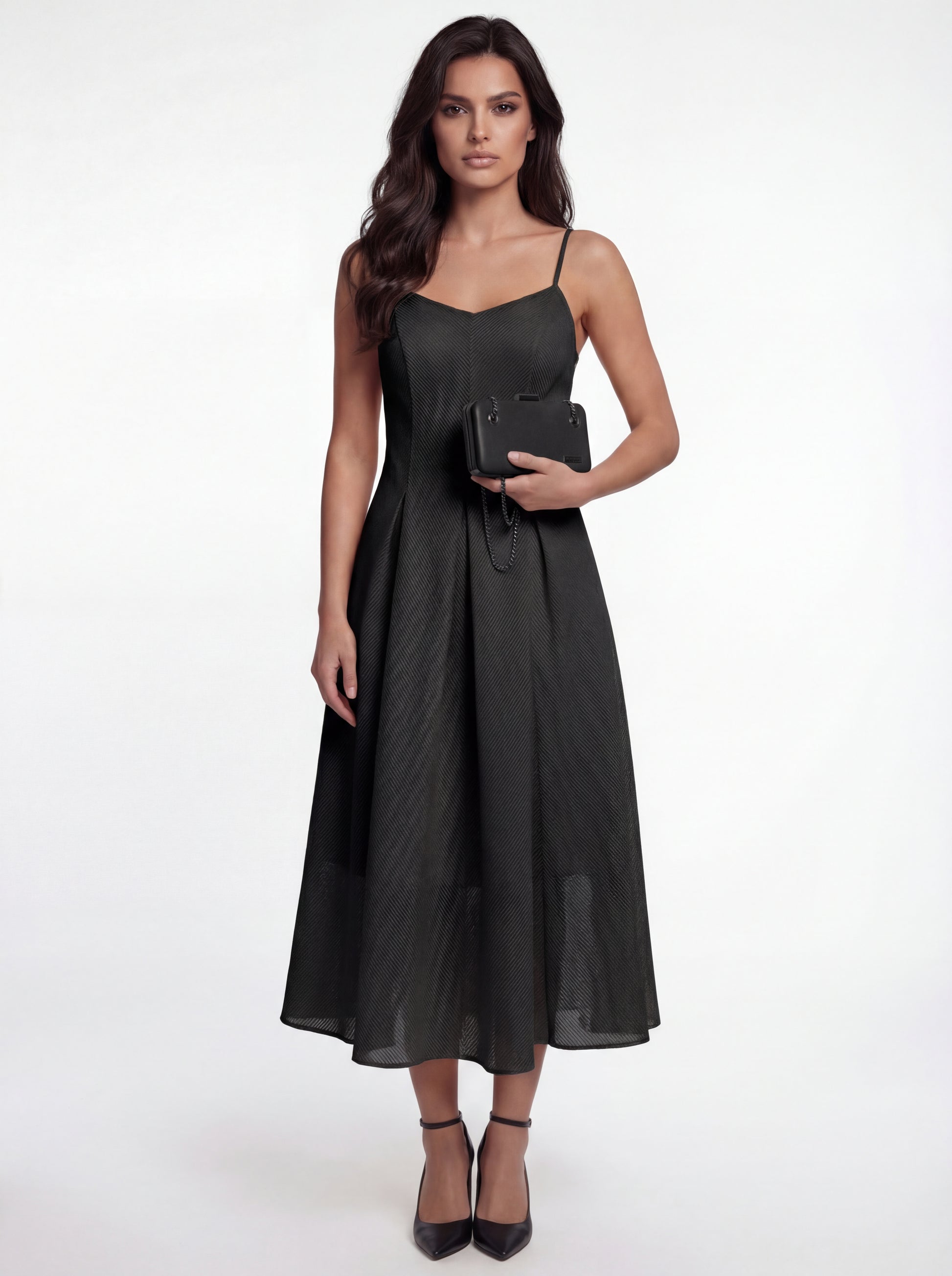 Woman wearing a black dress holding a clutch on a white background