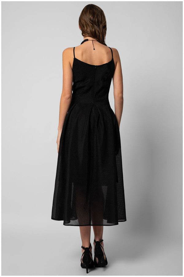 Woman wearing a black sleeveless elegant midi dress with fitted bodice and flared A-line skirt, viewed from the back