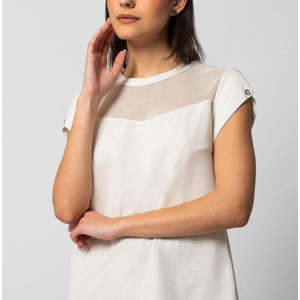 Woman wearing white short-sleeve TOP ARIA blouse with sheer neckline panel and textured finish