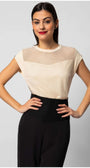 Woman wearing Aria Short-Sleeve Blouse in Ivory paired with black high-waist pants against gray backdrop