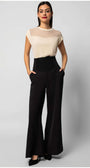 Woman wearing Aria Short-Sleeve Blouse in Ivory paired with high-waisted black wide-leg pants against white background
