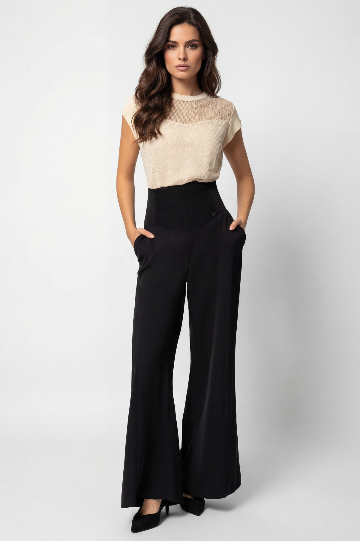 Woman wearing a beige top and black high-waisted pants on a white background