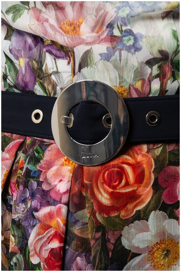 Close-up of the elegant midi dress Julia floral viscose fabric with a black belt featuring a large silver circular buckle.