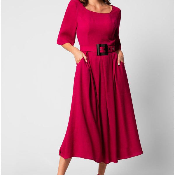 Woman wearing a vibrant elegant midi dress with square neckline, short sleeves, pleated skirt, and wide belt with sculpted buckle