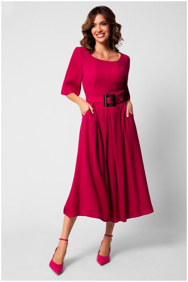 Woman wearing a vibrant elegant midi dress with square neckline, short sleeves, pleated skirt, and wide belt with sculpted buckle