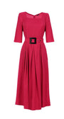 Pink elegant midi dress with square neckline, tailored sleeves, pleated skirt, and bold belt with sculpted buckle detail.