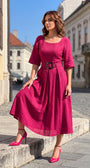 Pink Elegant Midi Dress, Charlotte. Worn with pink heels in a city square.