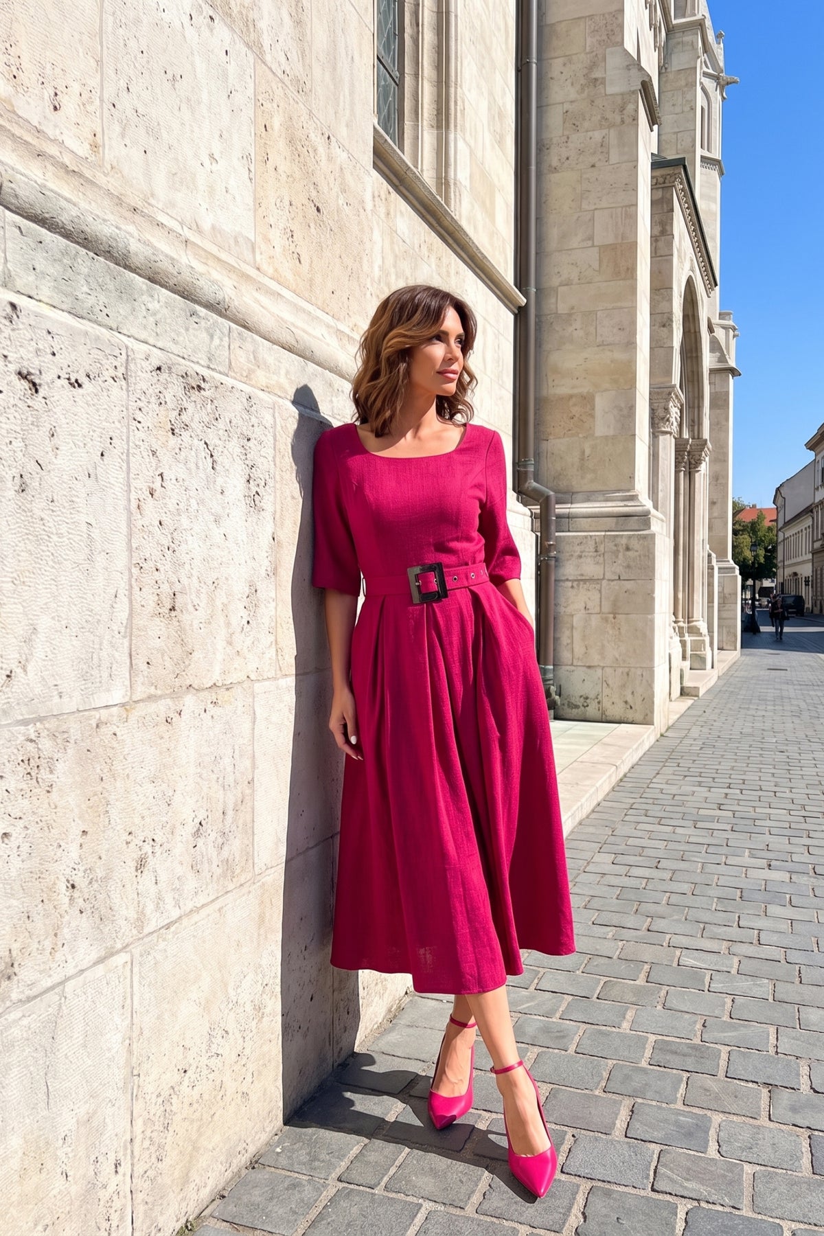 Pink Elegant Midi Dress, Charlotte. Worn beside a stone wall, side view.