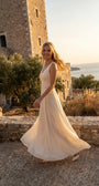 Rebeka ivory gown worn sleeveless against a coastal stone tower at golden hour