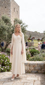 Rebeka ivory cape-sleeve gown worn at an outdoor garden wedding celebration
