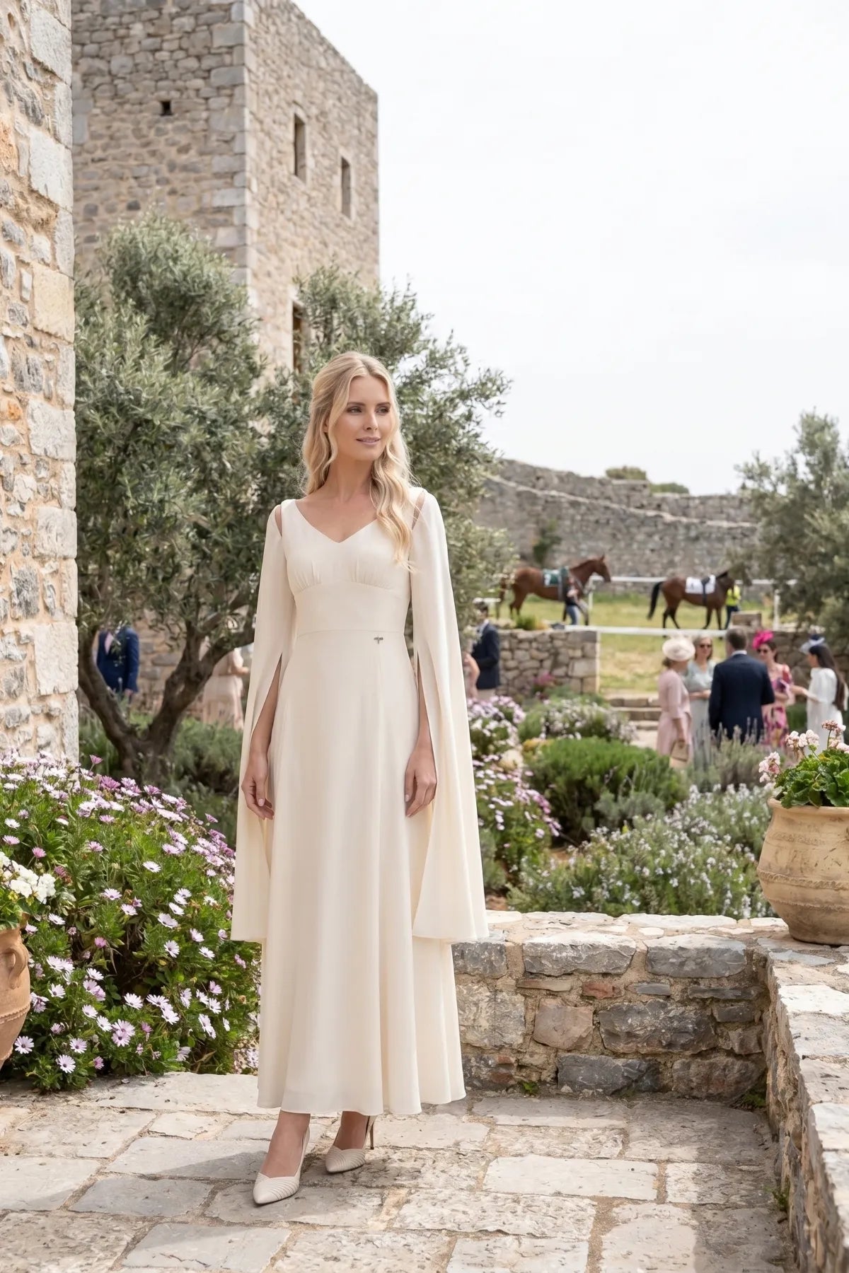 Rebeka ivory cape-sleeve gown worn at an outdoor garden wedding celebration
