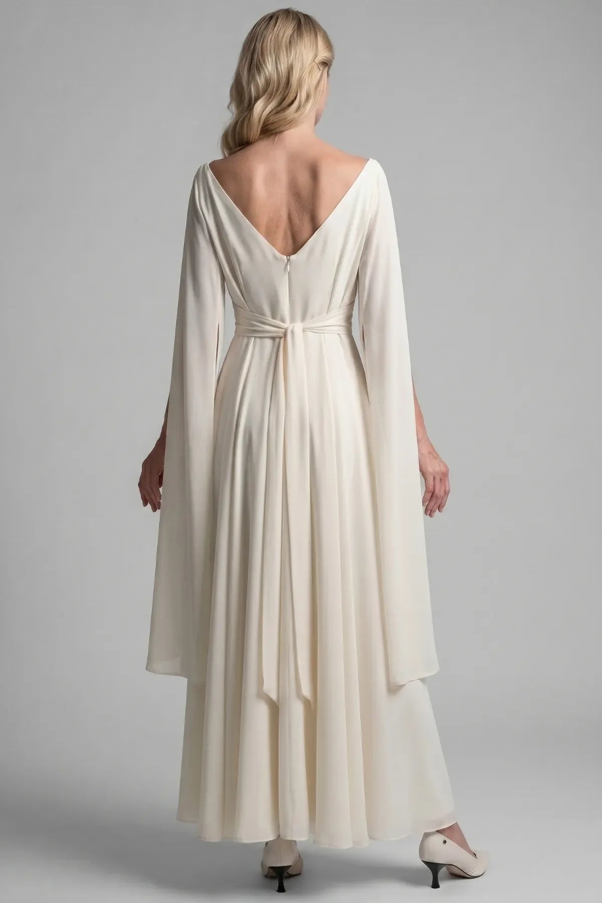 Back of the Rebeka ivory gown with V back, concealed zipper, waist tie and sheer cape sleeves
