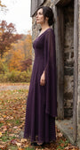 Rebeka plum gown worn in a brick garden archway with autumn foliage and pumpkins