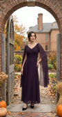 Rebeka plum drape-sleeve gown worn against an autumn stone setting with falling leaves