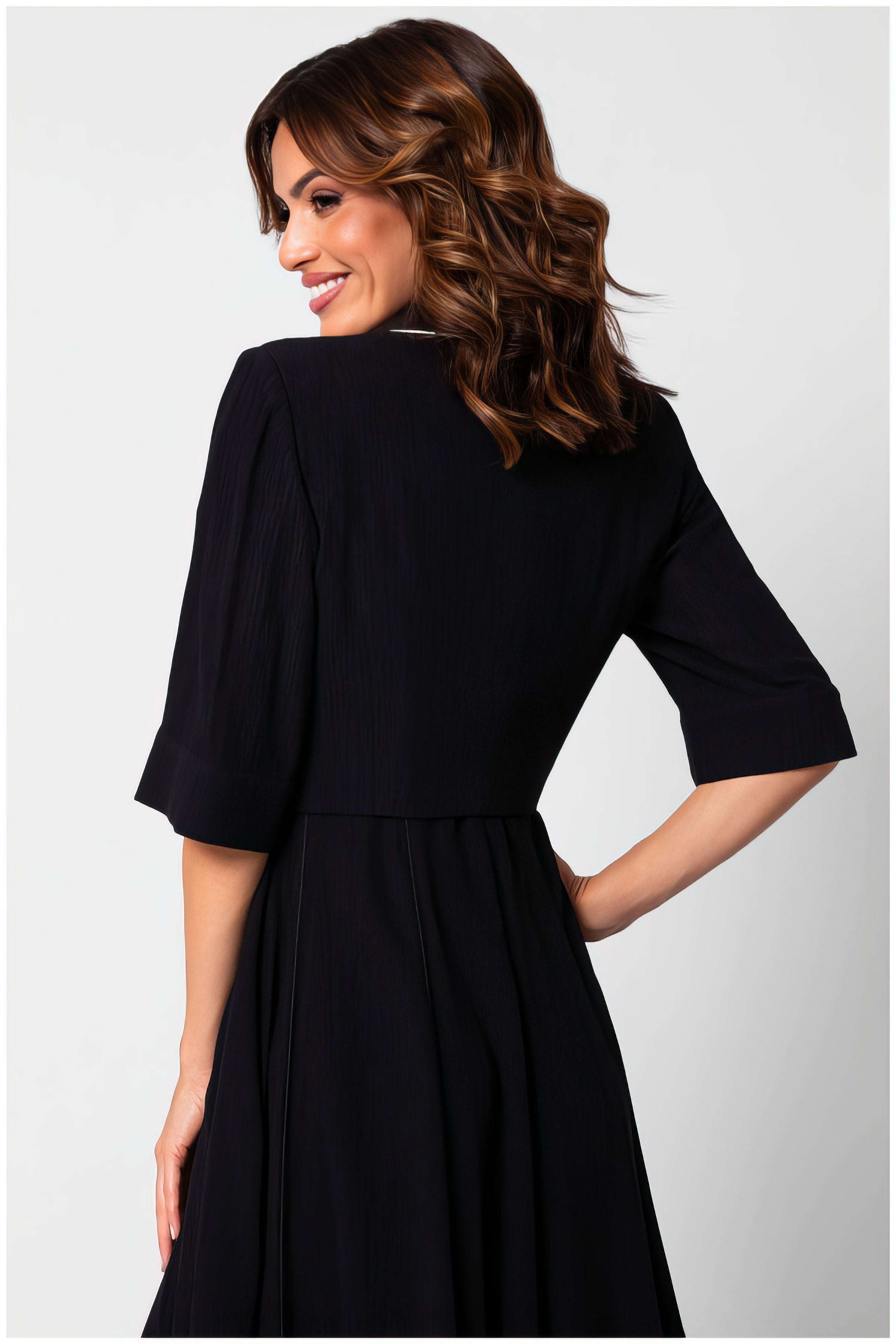 Woman wearing the Rina Cropped Blazer in black with a structured design and elegant three-quarter sleeves