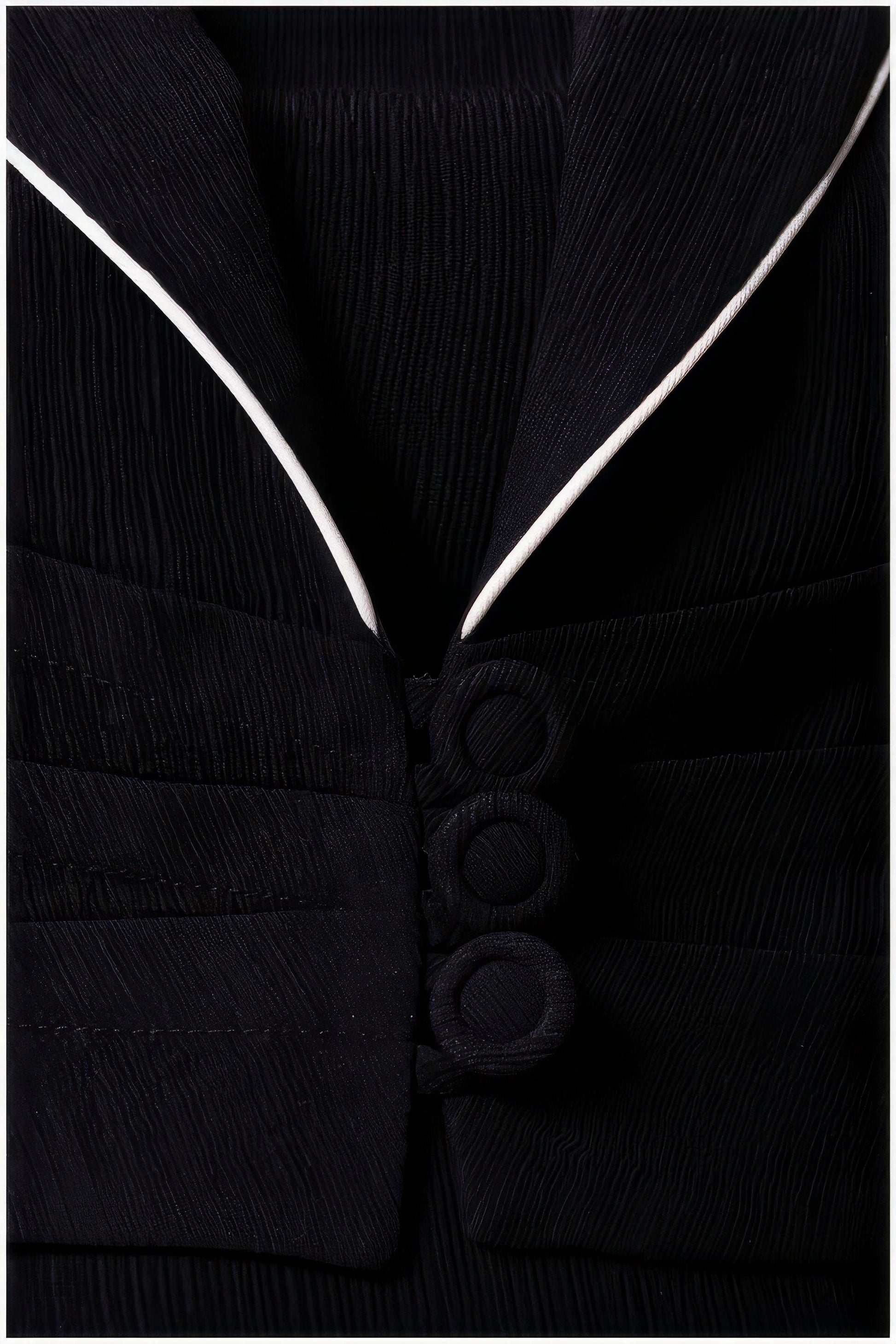 Close-up of the Rina Cropped Blazer showing textured fabric, three fabric-covered buttons, and contrasting white trim on collar.