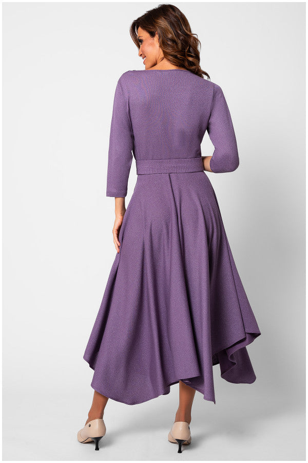 Woman wearing a purple dress with a fitted bodice and flowing skirt on a white background