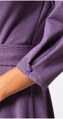 Close-up of a person wearing a purple garment with a white background