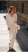 Woman walking outdoors wearing Jody Tailored Cardigan in Ivory styled with matching high-waist pants and lace top