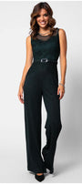 Woman wearing a midnight green Lace Overalls fitted bodice jumpsuit with wide-leg trousers and matching belt, smiling confidently.