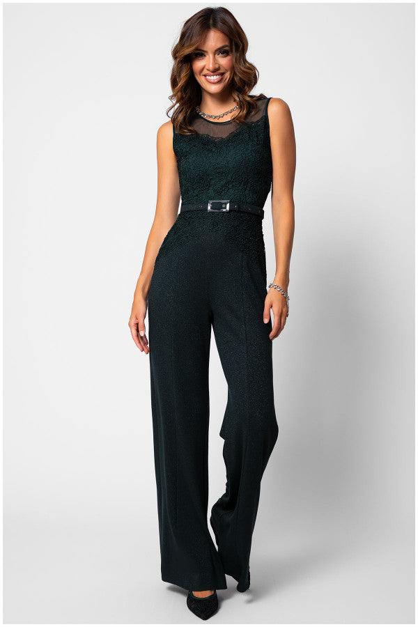 Woman wearing a midnight green Lace Overalls fitted bodice jumpsuit with wide-leg trousers and matching belt, smiling confidently.