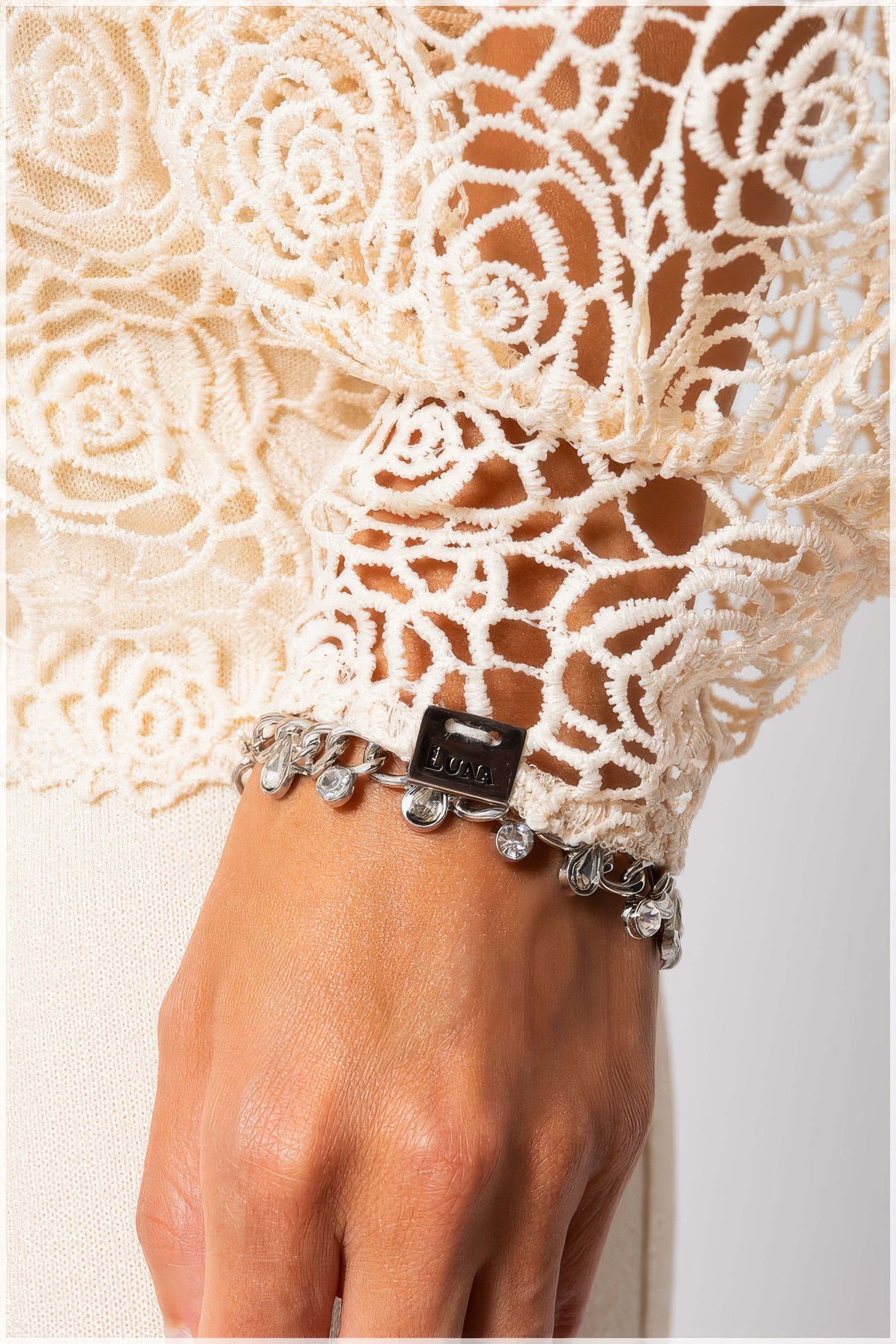 Close-up of intricate lace cuff detail with charms on Jody Lace Belted Sweater in Ivory by Luna Fashion House