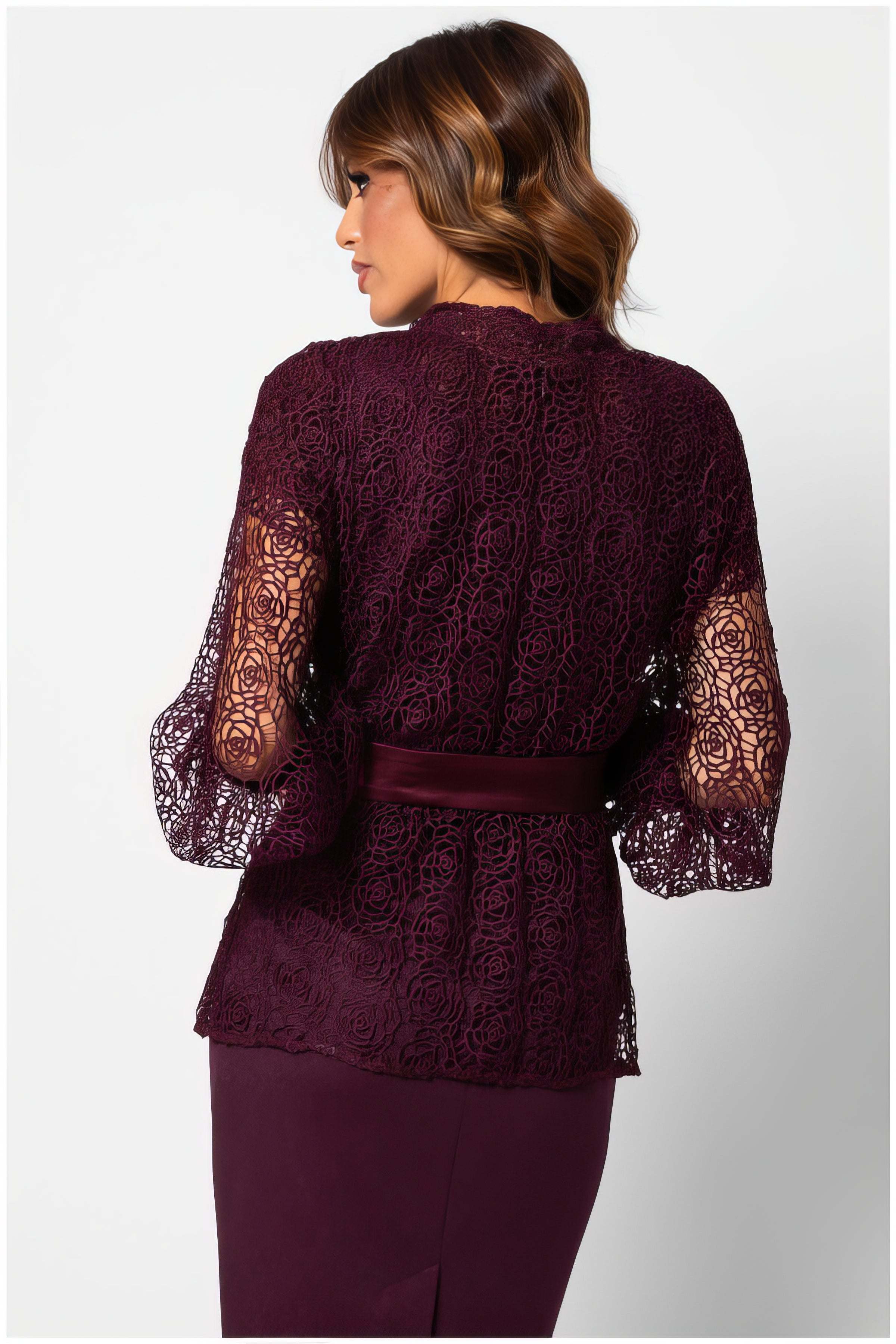 Rear view of a model wearing the Jody Lace Belted Sweater in Bordeaux with intricate lace and satin belt detailing