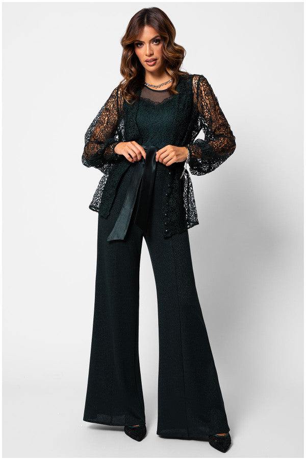 Woman wearing Midnight Green floral green lace cardigan Sweater Jody with semi-sheer sleeves and waist tie over black wide-leg trousers