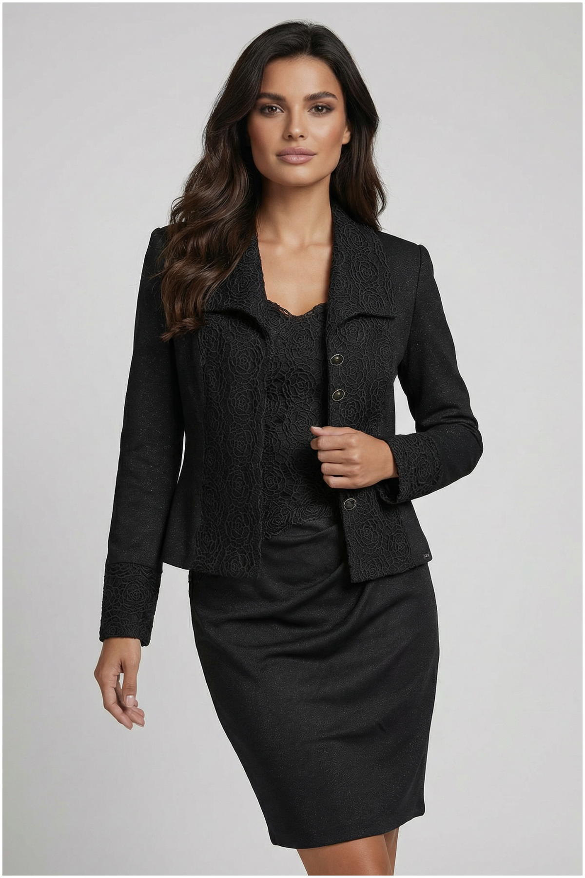 Woman wearing a black suit with a jacket and skirt on a gray background