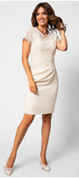 Woman wearing fitted lace cocktail dress JODY dress with lace top and short sleeves, standing and smiling against white background