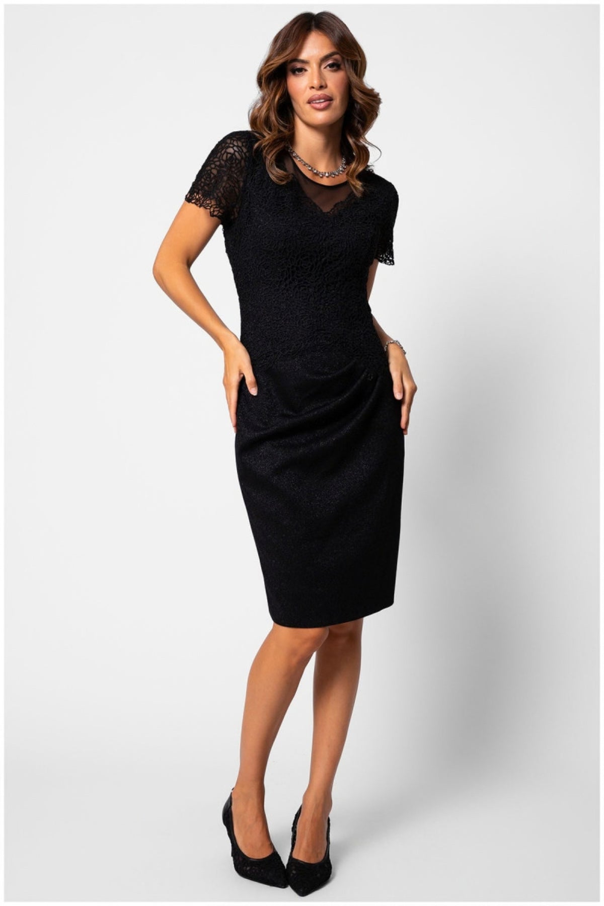 Black Lace Cocktail Dress, Jody. Front view on the model, short lace sleeves and a draped skirt.