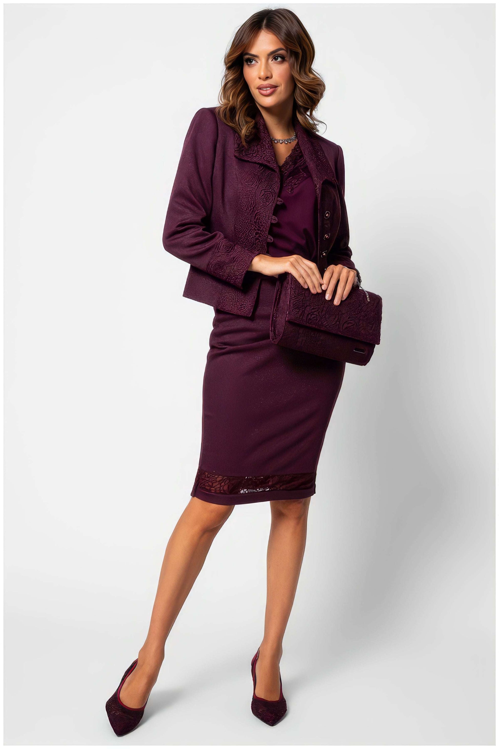 Woman wearing Jody Elegant Lace Blouse in Bordeaux styled with matching skirt jacket and purse, poised against white background