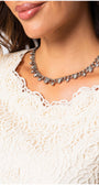 Close-up of a woman wearing the Jody Elegant Lace Blouse in Ivory with delicate lace detailing and a silver necklace