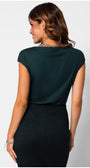 Woman wearing elegant blouse Midnight Green Jody Blouse with cap sleeves paired with a black high-waisted skirt, back view.