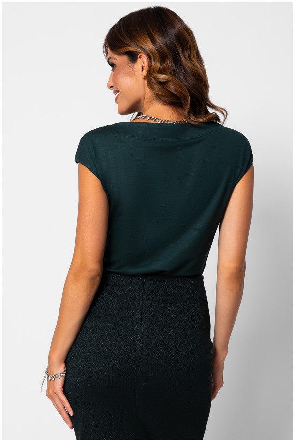 Woman wearing elegant blouse Midnight Green Jody Blouse with cap sleeves paired with a black high-waisted skirt, back view.