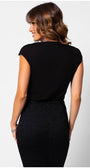 Woman wearing black lace elegant blouse JODY, styled with a fitted high-waist skirt, showing the back view of the top.