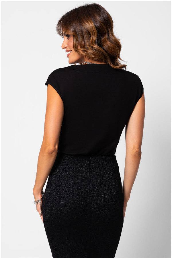 Woman wearing black lace elegant blouse JODY, styled with a fitted high-waist skirt, showing the back view of the top.