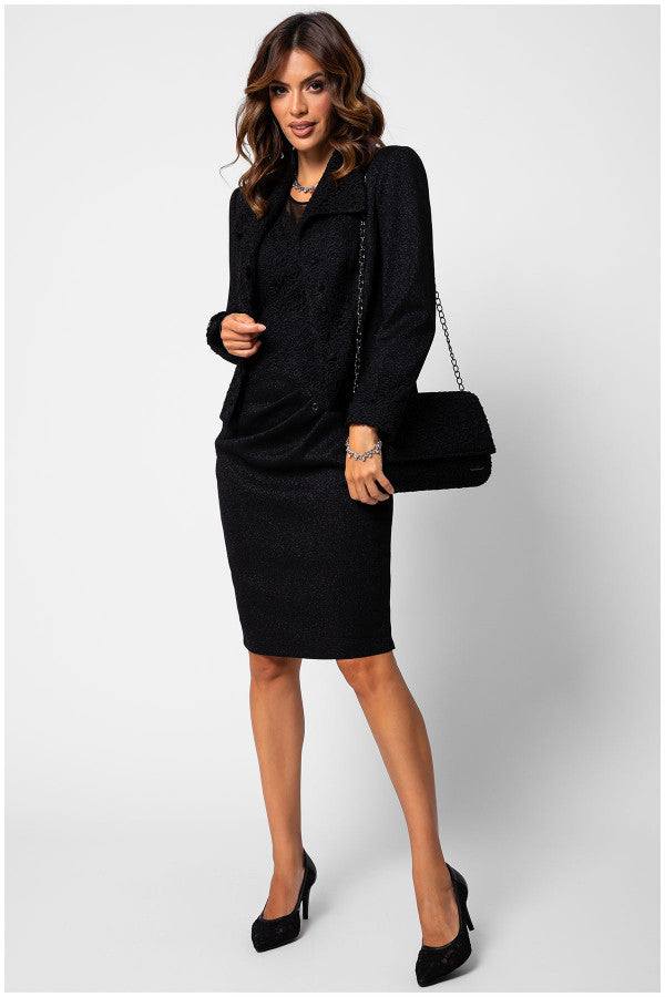 Woman in black dress holding a Jody black clutch bag with floral lace overlay and chain strap for evening wear