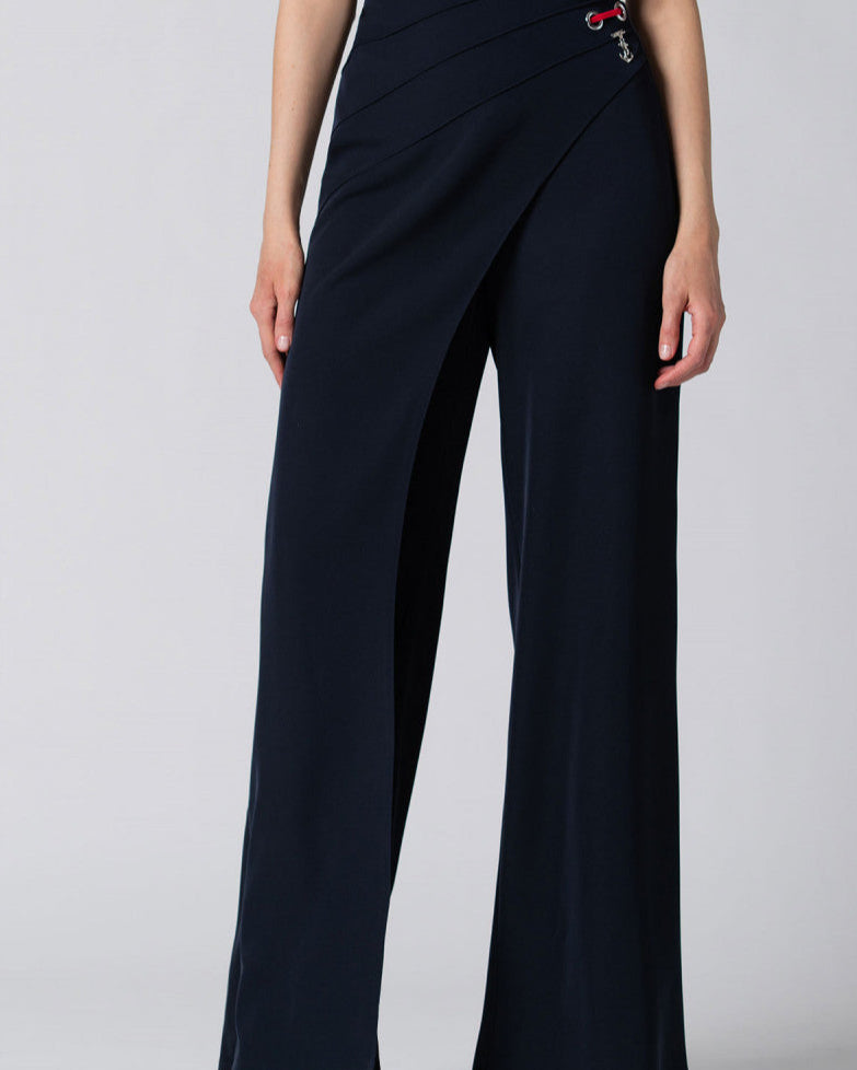 Woman wearing high-waisted navy wide-leg pants with wrap detail and decorative metal eyelets on the side