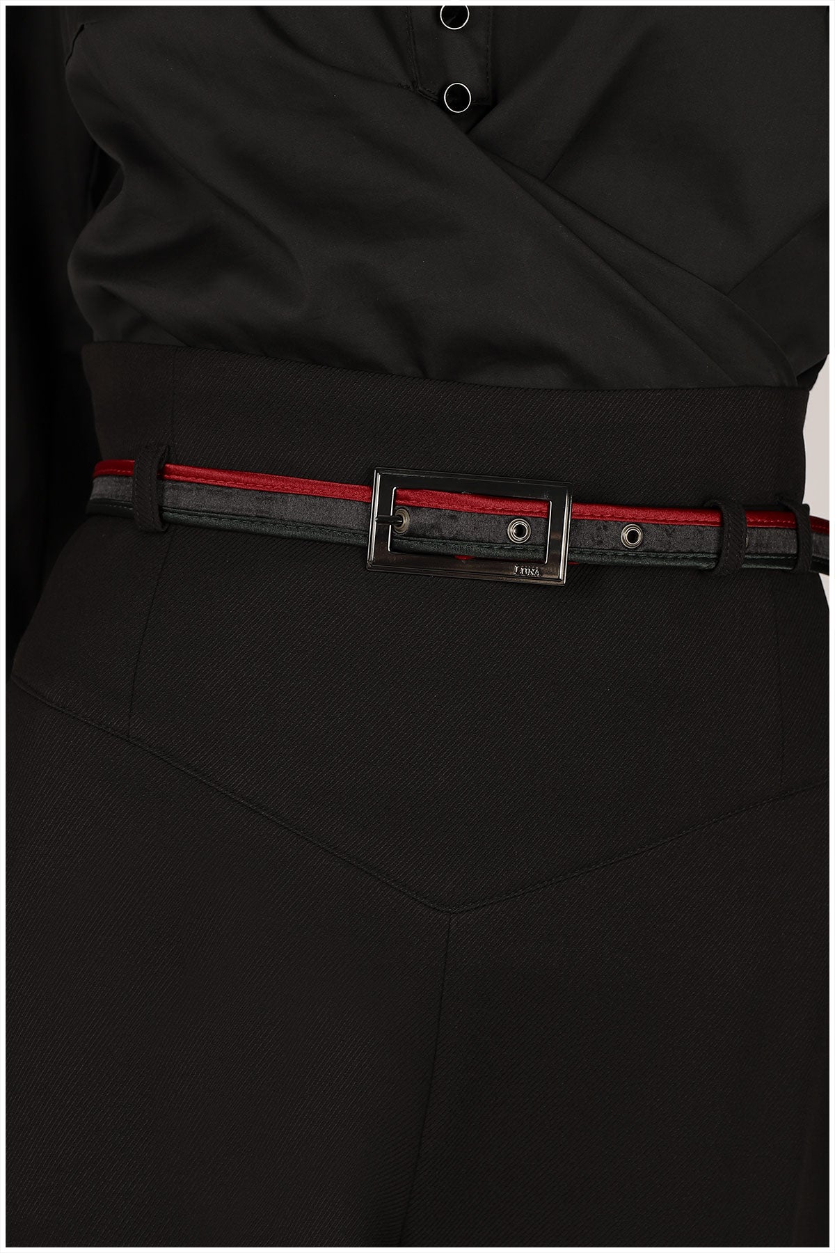 Black pants with a red and black belt on a white background