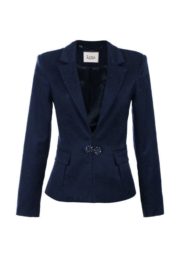 Navy blue blazer with a decorative brooch on a white background