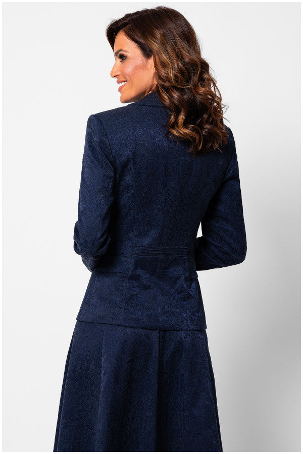 Woman wearing a navy blue suit on a light gray background